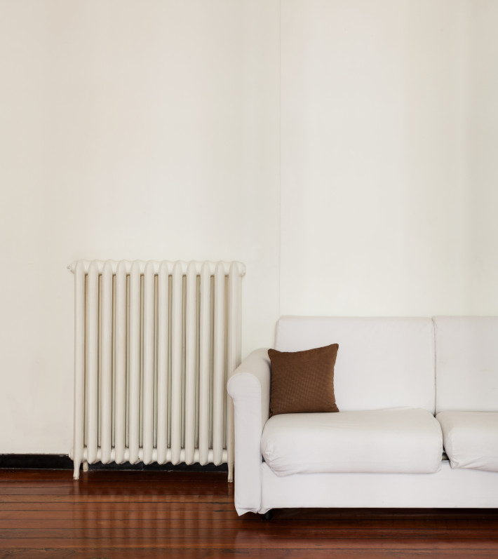 heizkosten Heizkörper neben Sofa